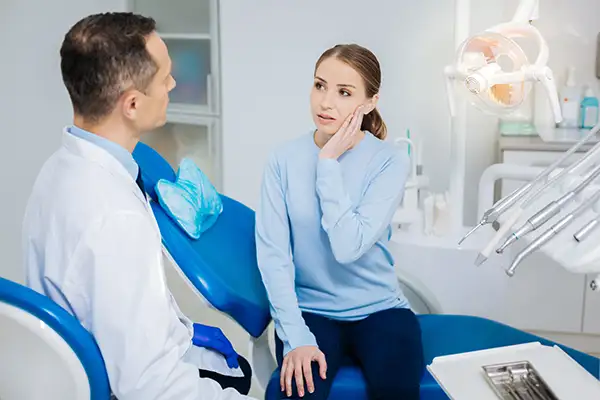 Concerned patient discussing her tooth pain with her dentist while sitting in a dental chair at Coulter Family Dentistry in Spokane Valley, WA